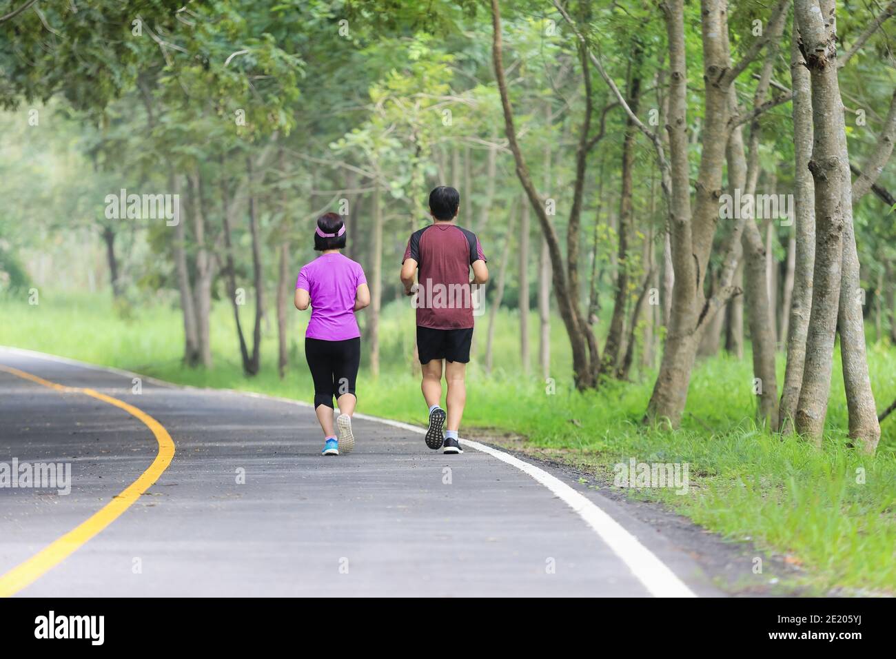 Asian middle aged couple jogging and running in park Stock Photo - Alamy