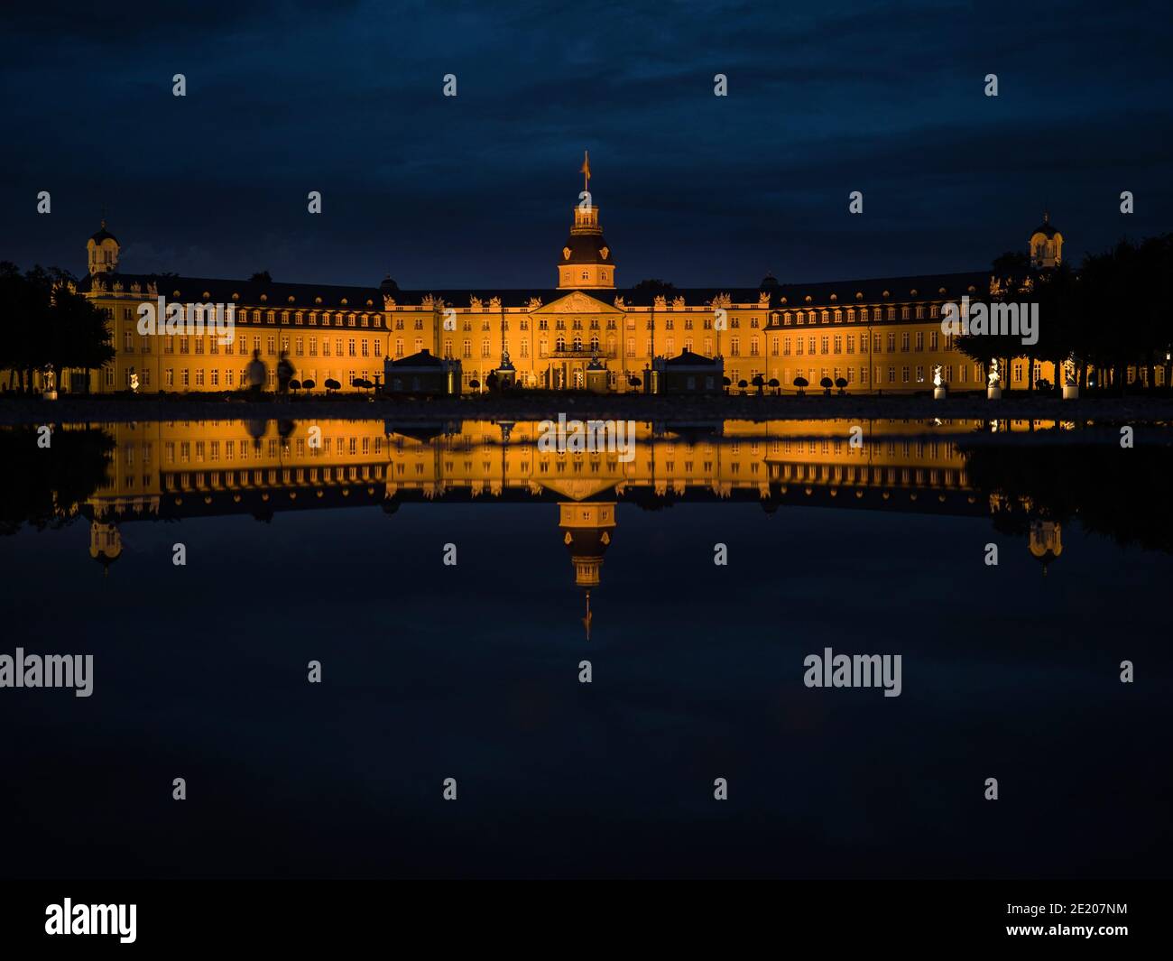 Panorama night reflection of illuminated yellow stone Schloss Karlsruhe Castle Palace Schlosspark in Baden Wurttemberg Germany in Europe Stock Photo