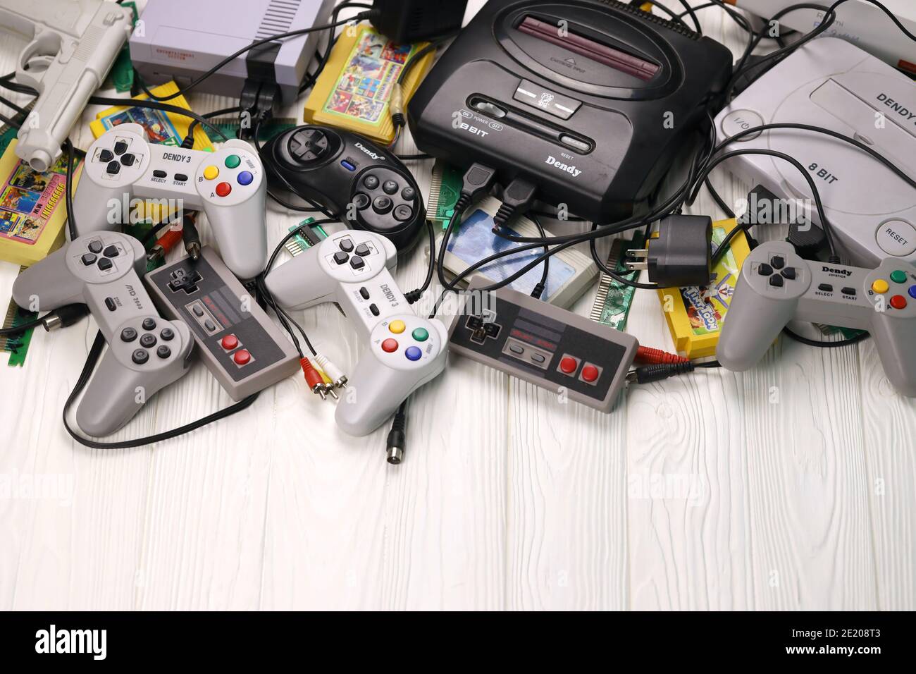 KHARKOV, UKRAINE - DECEMBER 27, 2020: Pile of old 8-bit video game consoles and many gaming accessories like a joysticks and cartridges. Old school re Stock Photo