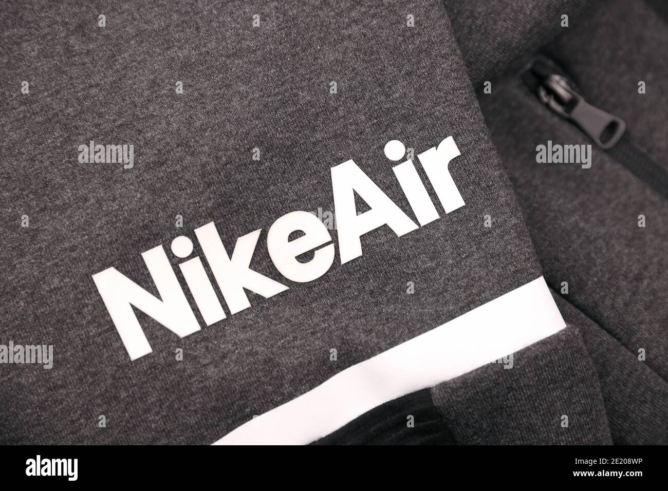 KHARKOV, UKRAINE - DECEMBER 20, 2020: Nike air logo on grey sportwear fragment. Nike is multinational corporation engaged in manufacturing an Stock Photo -