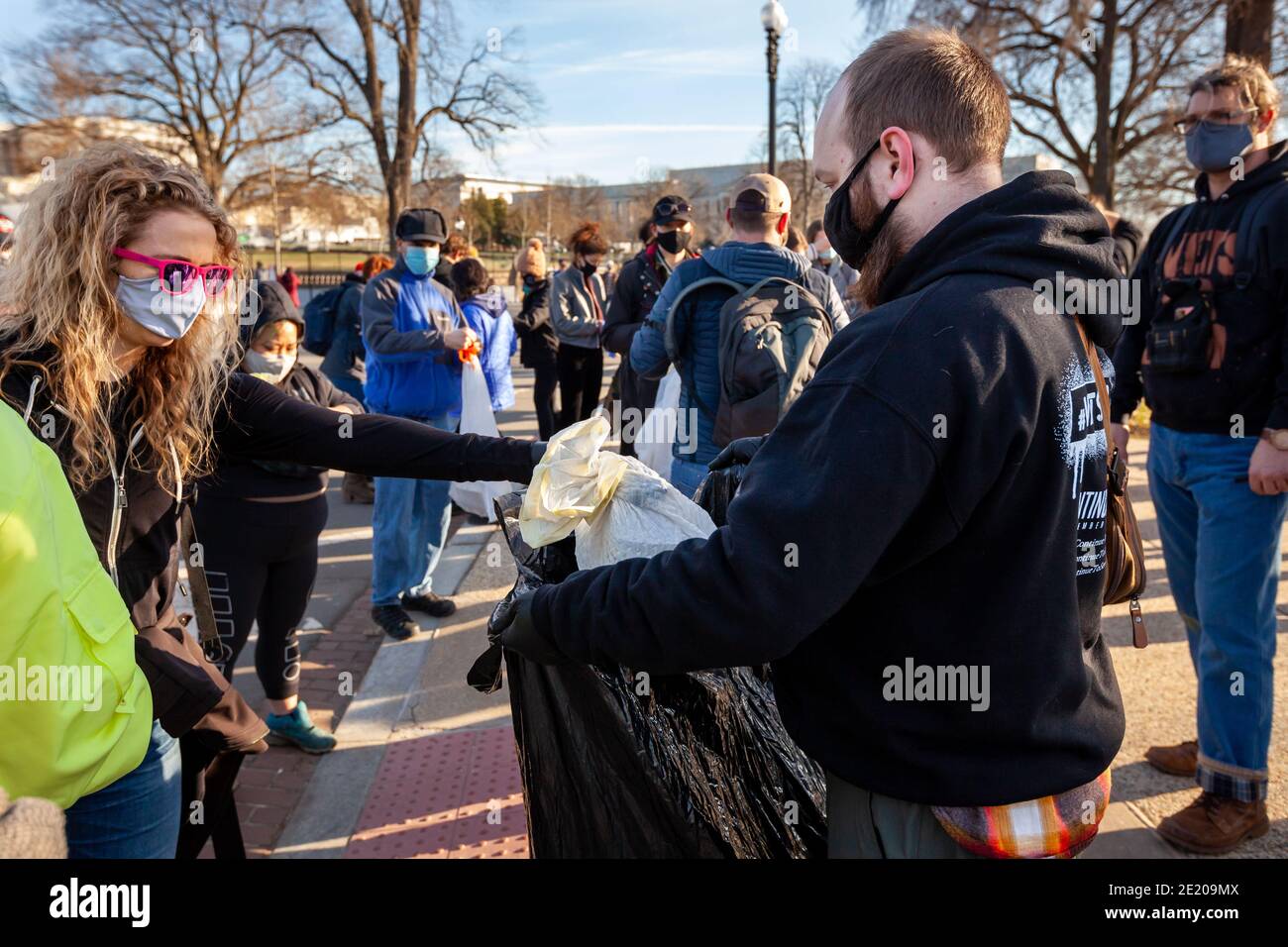 Washington, DC, USA, 10 January 2021.  Pictured: A volunteer hands in her trash bag during Operation Clean Sweep.  The event was an effort to clean up trash and propaganda left behind by fascists and Trump supporters following the January 6 Capitol insurrection.  It was hosted by Continue to Serve, an anti-racist organization of military veterans.  Credit: Allison C Bailey/Alamy Live News Stock Photo