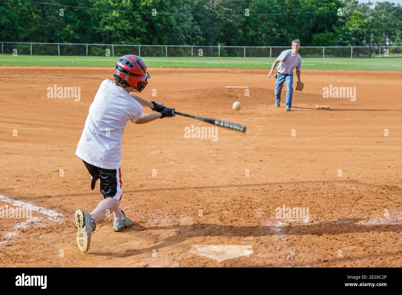 Alabama Dothan Westgate Park Baseball Hardy Field,father pitches son hits bat batting swings practice man boy, Stock Photo