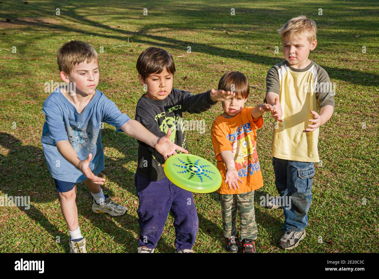 Alabama Dothan park Hispanic boys catching Frisbee, Stock Photo