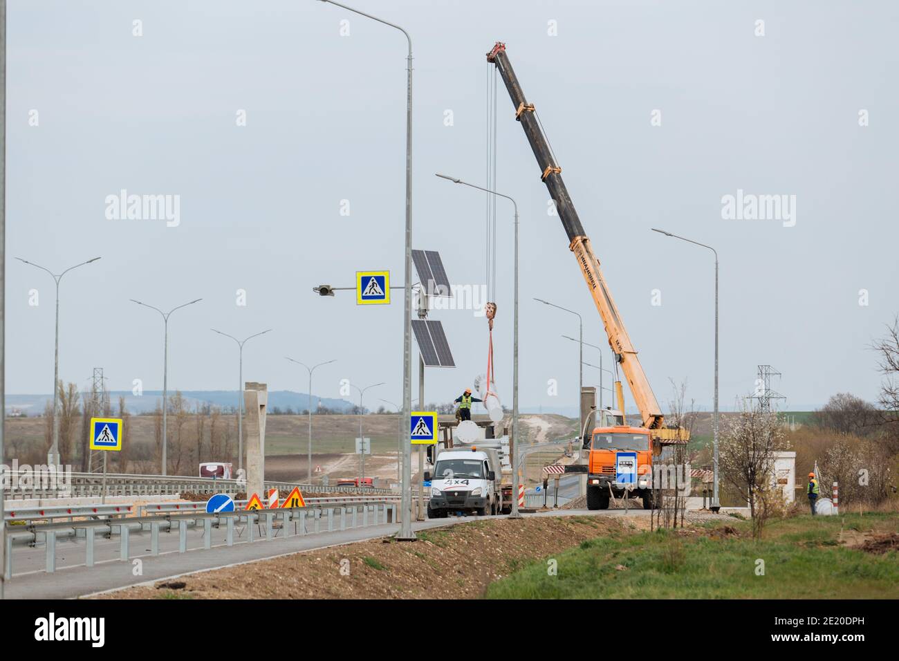Yellow mobile crane on a construction site. Road construction works Stock Photo
