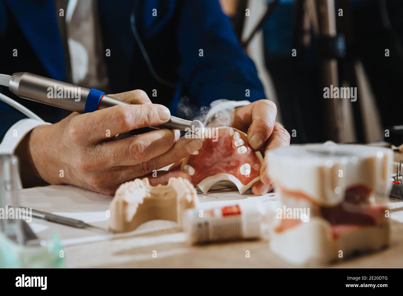 A dental technician processes a cast from the jaw of the patient. Stock Photo