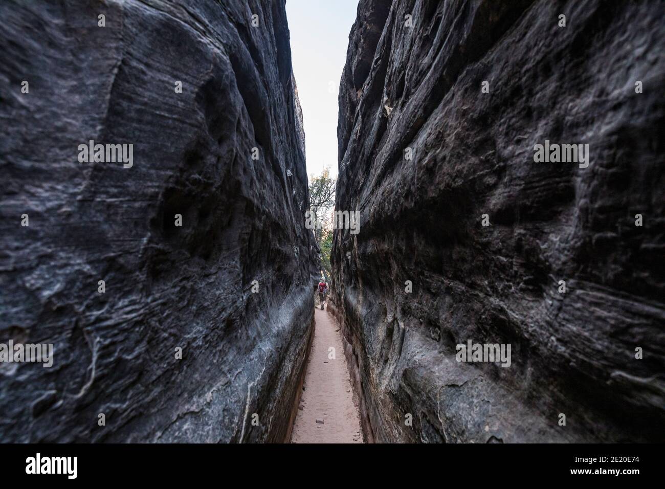 Hiking in a narrow passage on the Chelsler Park trail. Canyonlands National Park, Utah, USA. Stock Photo