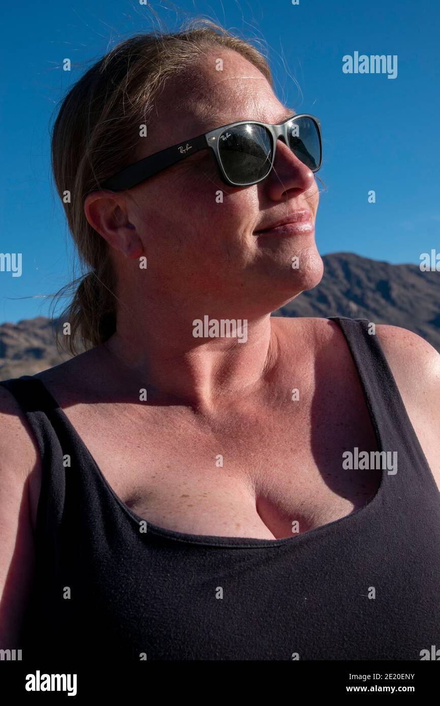 A woman poses for photos while visiting The Racetrack in Death Valley National Park. Stock Photo
