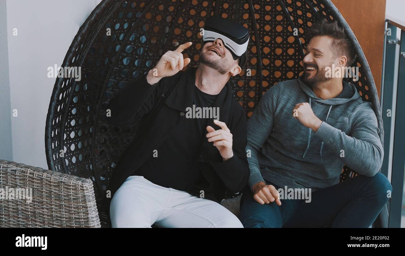 Virtual World Cheerful Gay Couple Wearing Vr Glasses And Relaxing On The Balcony High Quality Photo Stock Photo Alamy