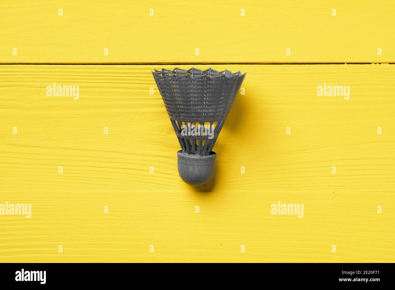 Gray shuttlecock on yellow background top view Stock Photo