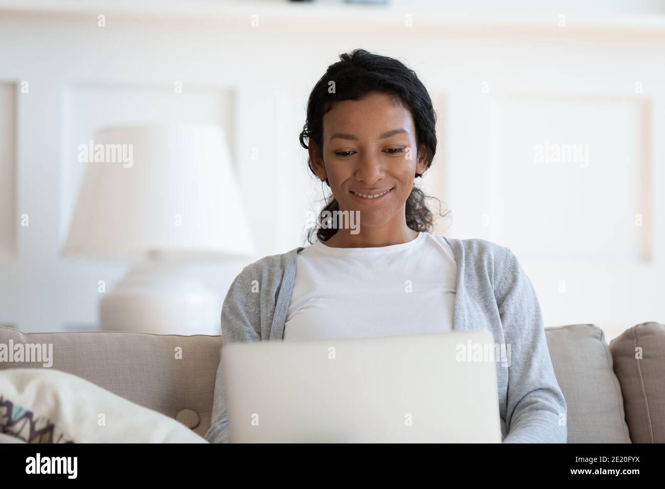 Happy young african american woman using computer at home Stock Photo ...