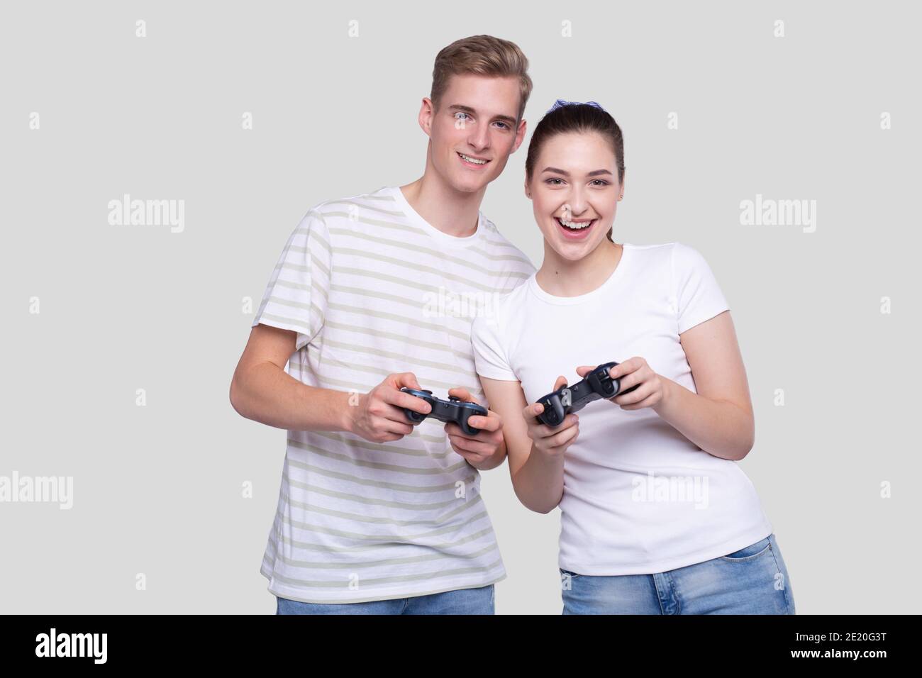 Couple Standing with Joysticks in Hands Smilling Isolated Stock Photo