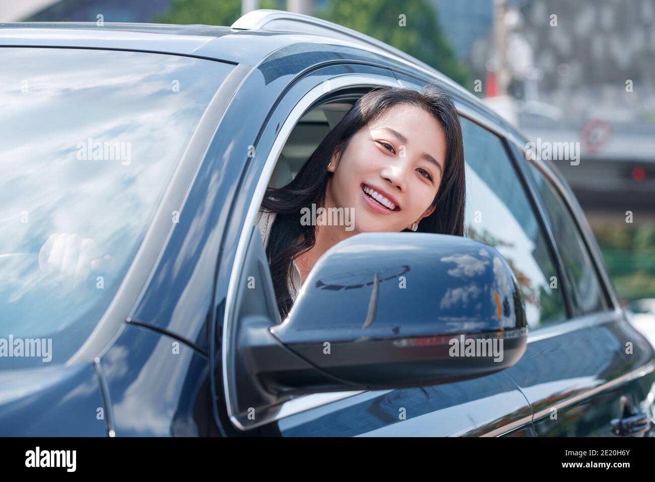 Driving a car young women head out of the window Stock Photo