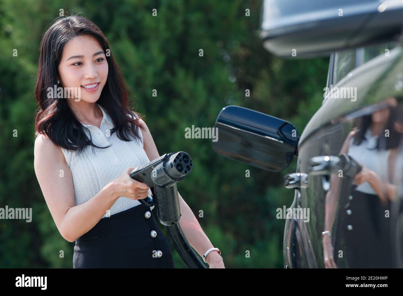 Young woman holding a gun for car battery Stock Photo - Alamy