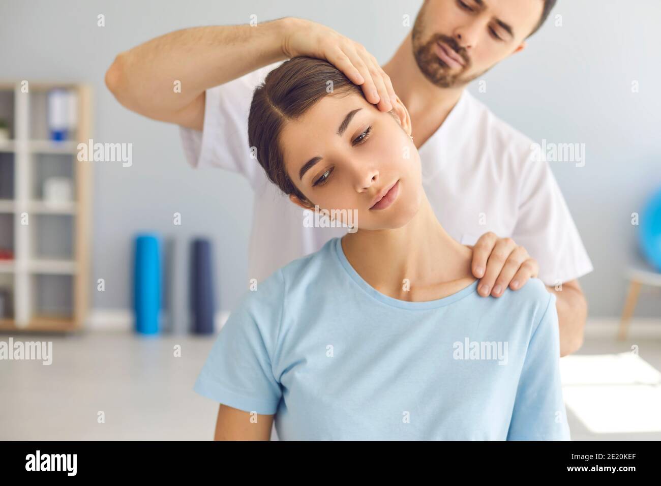 Man doctor chiropractor or osteopath setting womans neck joints with hands during visit and treatment Stock Photo