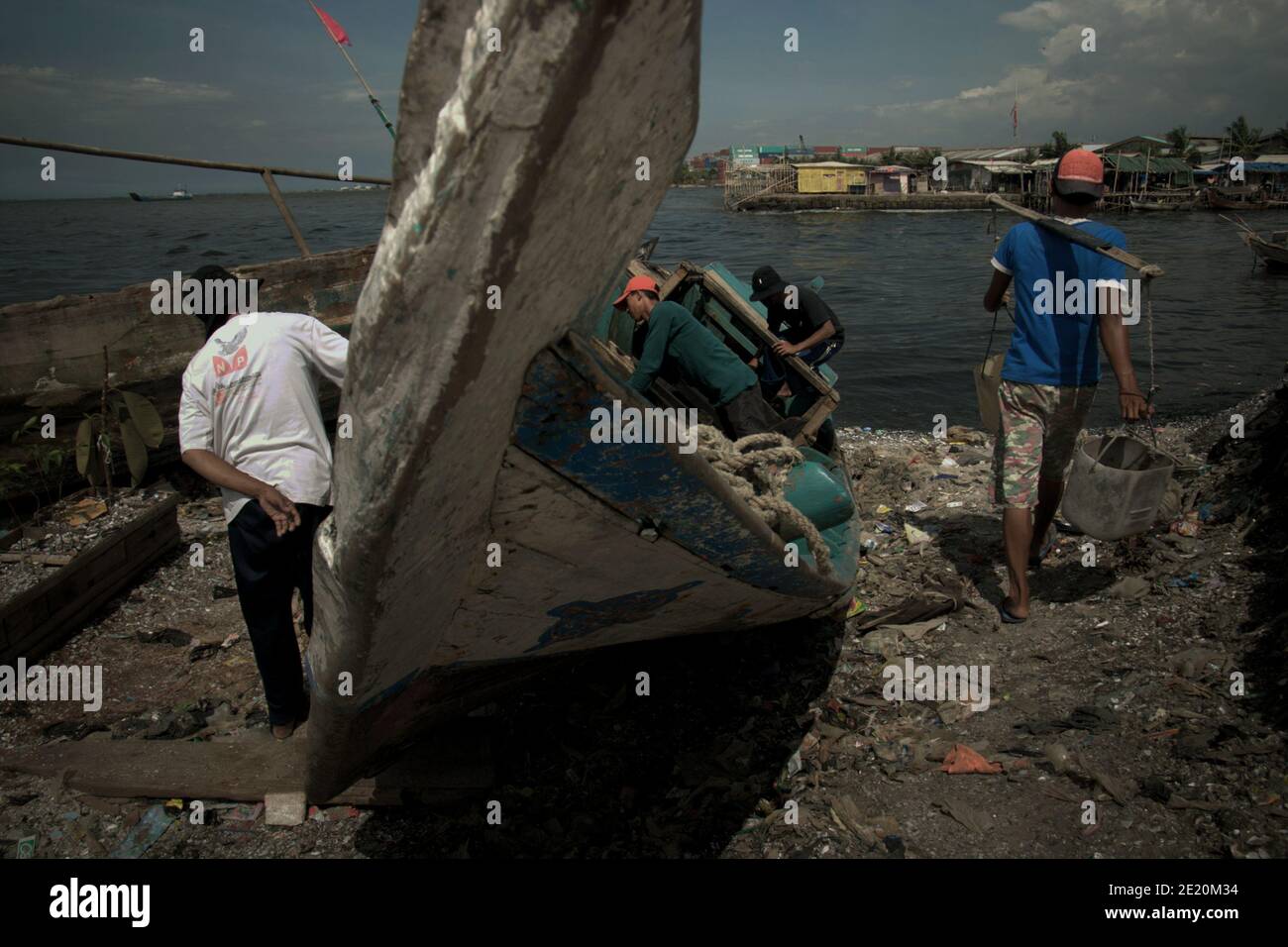 Men repairing fishing boat in Cilincing, a fishing village in the coastal area of Jakarta, Indonesia. Archival photo (2008). Stock Photo