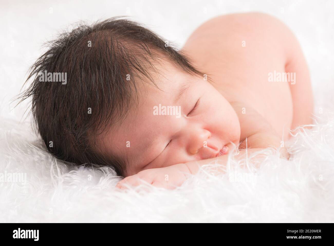 Cute newborn baby boy sleeping face down on a soft white fluffy cloth Stock Photo Alamy