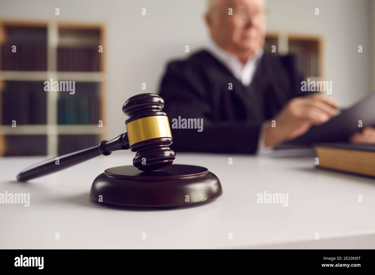 Close-up of wooden gavel placed on sound block on judge's table during court hearing Stock Photo