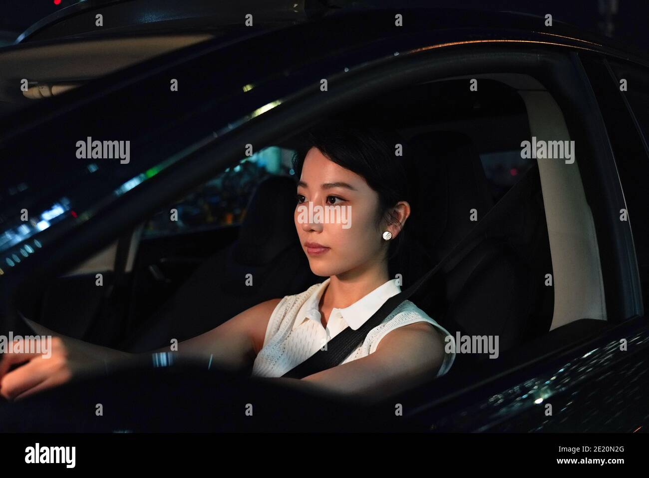 Driving a car at night young woman Stock Photo