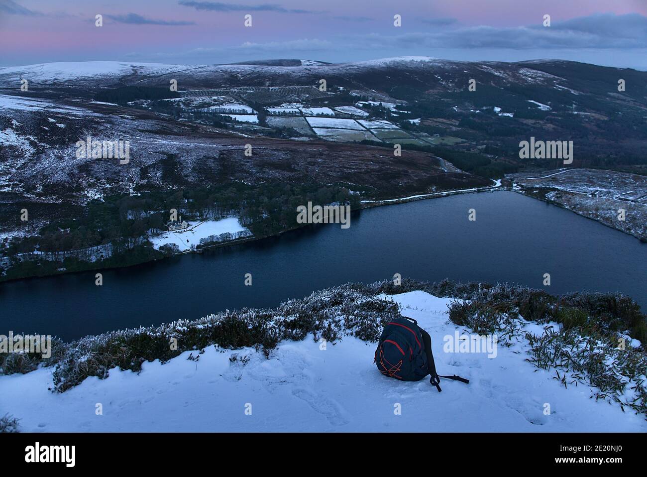 Scenic evening view over Lough Bray Upper lake seen from Eagles Crag, Ballylerane, Co. Wicklow, Ireland. Travel rucksack in foreground Stock Photo