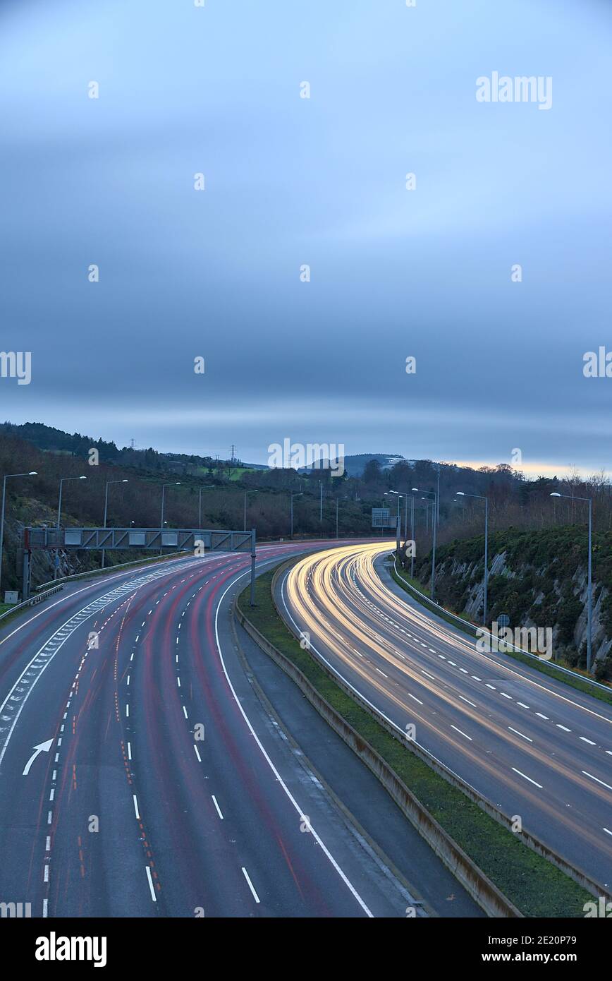 Beautiful very long exposure evening view of light trails of vehicles on motorway M50 Dublin, Ireland. Transportation during Level 5 in Dublin Stock Photo