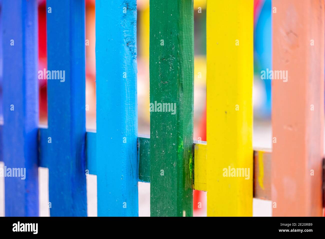 Part of wooden, rainbow colorful painted fence on a sunny hot summer ...