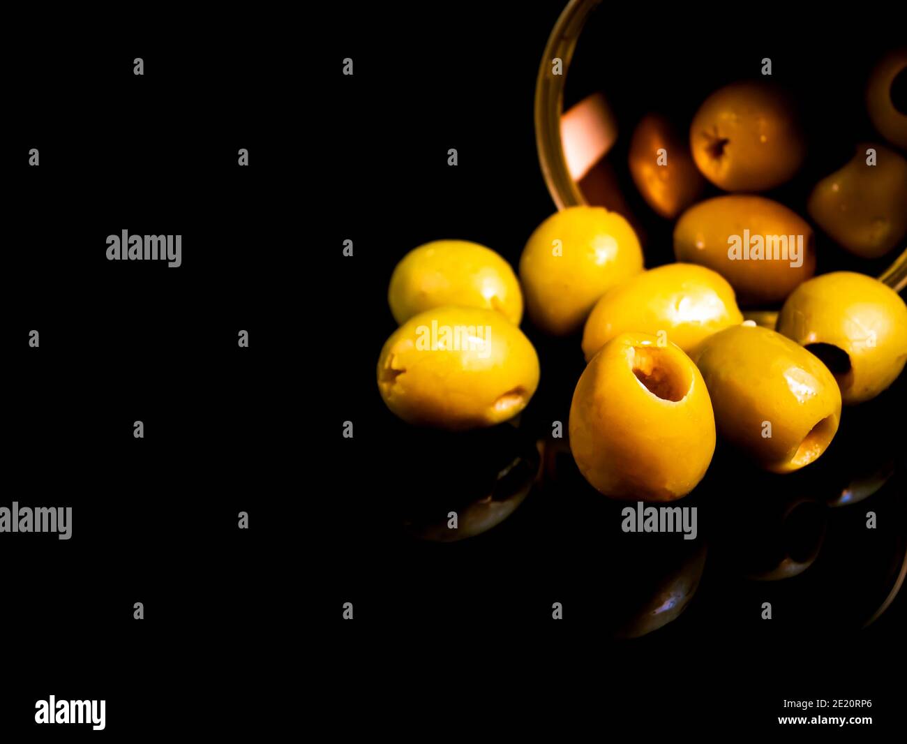 Green olives in a tin can on a black background. Green olive fruits