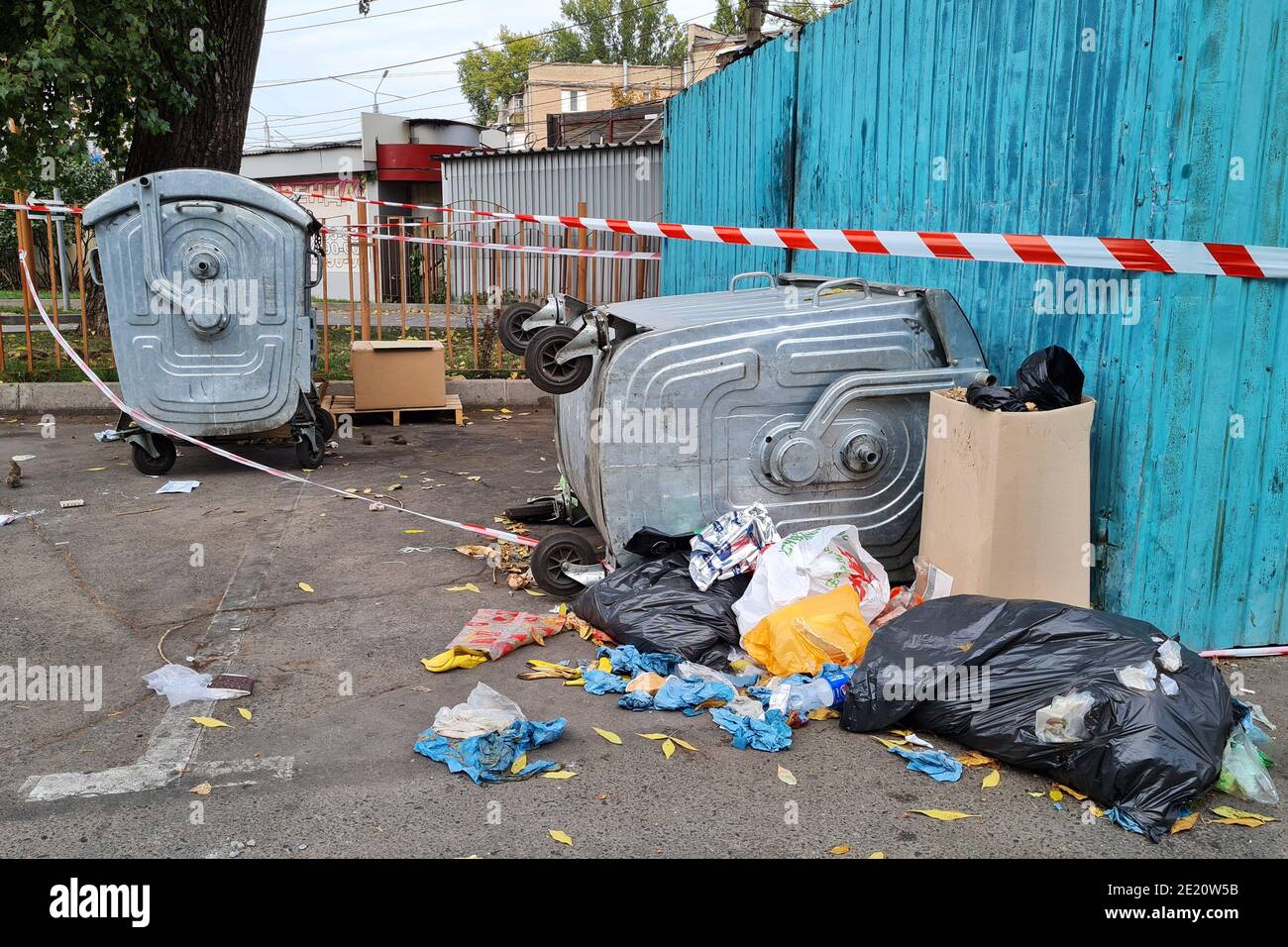 Trash in overloaded inverted garbage bins in courtyard of residential