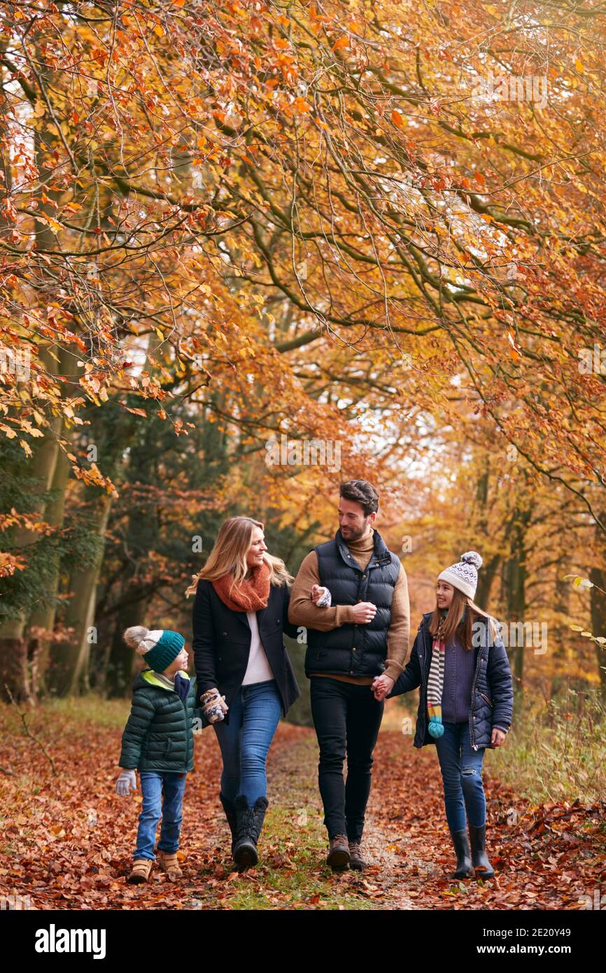 Family Walking Arm In Arm Along Autumn Woodland Path Together Stock ...