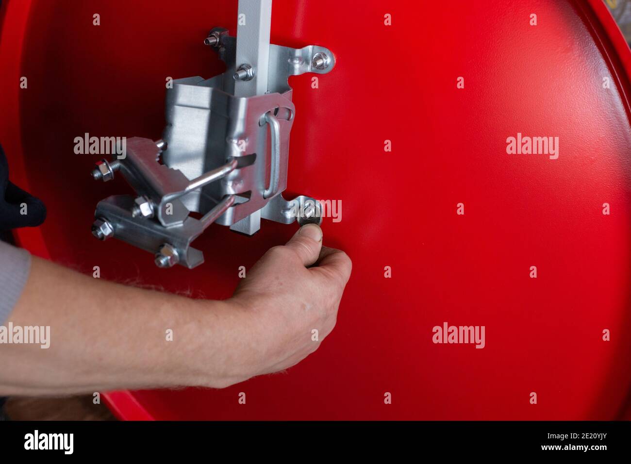 man assembles a satellite TV dish to be installed on the roof of a house. Close-up. Autonomous antenna in a private house. Stock Photo