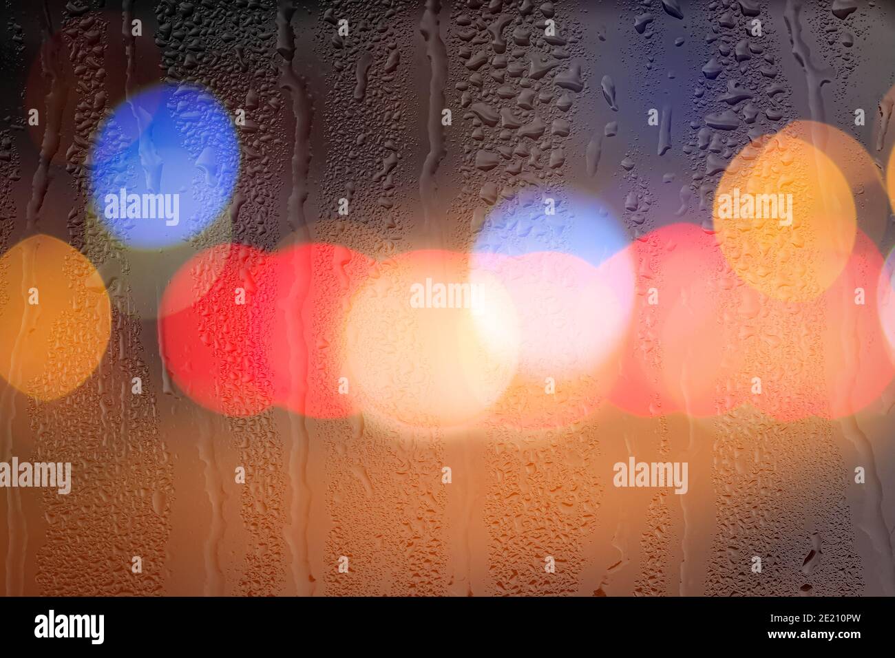 Night city lights and car headlights through rainy glass. Rain and bad