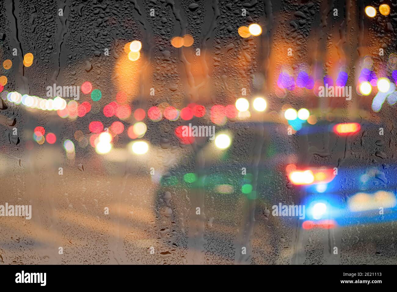 Night city lights and car headlights through rainy glass. Rain and bad
