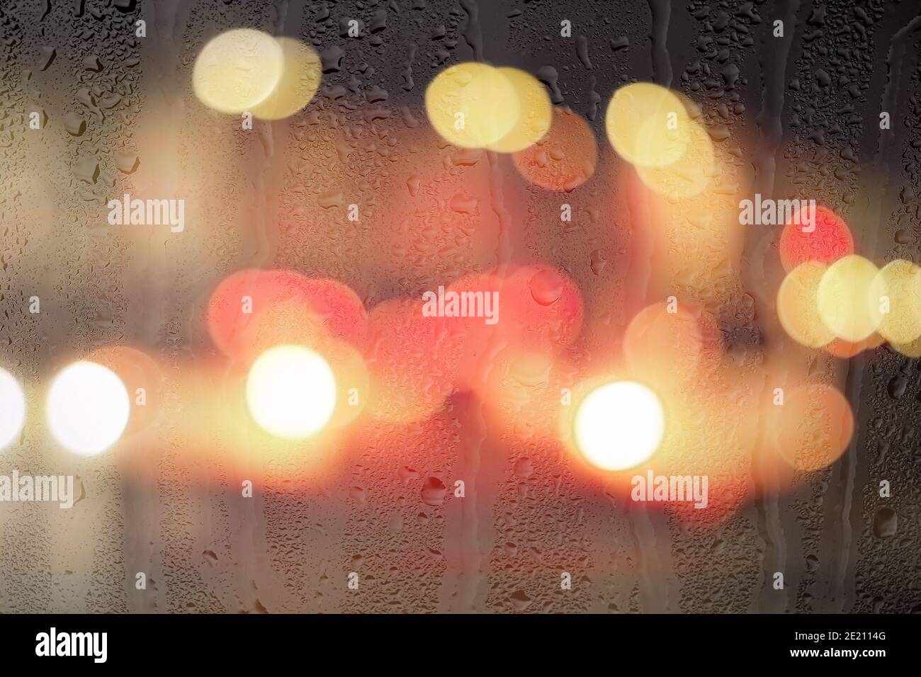 Night city lights and car headlights through rainy glass. Rain and bad