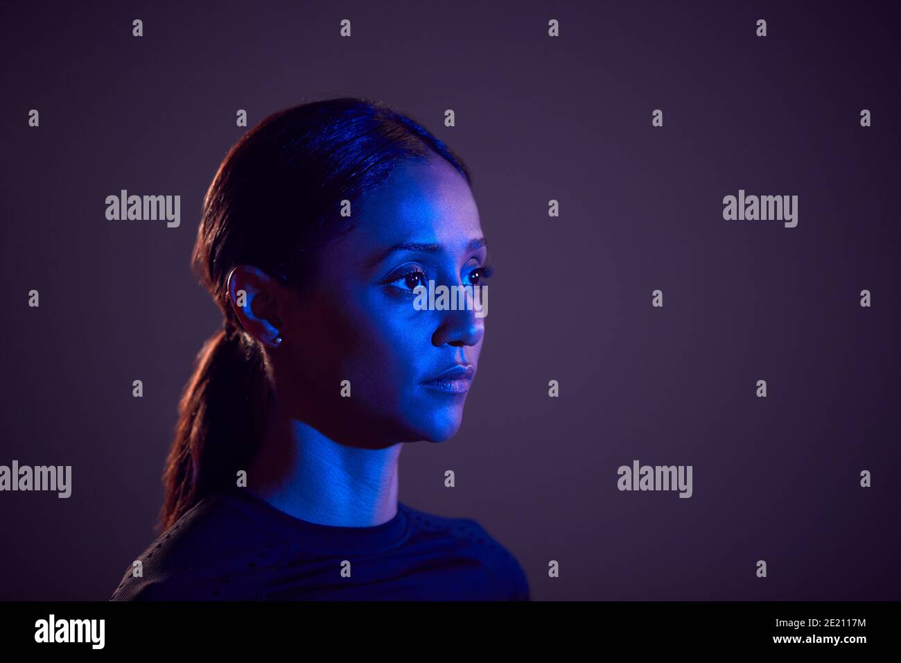 Studio Profile Shot Of Woman With Face Illuminated By Blue Light Stock  Photo - Alamy