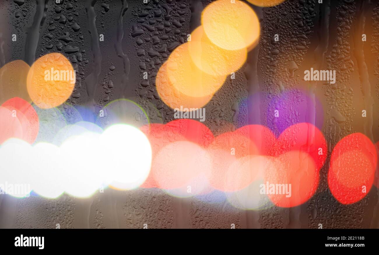 Night city lights and car headlights through rainy glass. Rain and bad