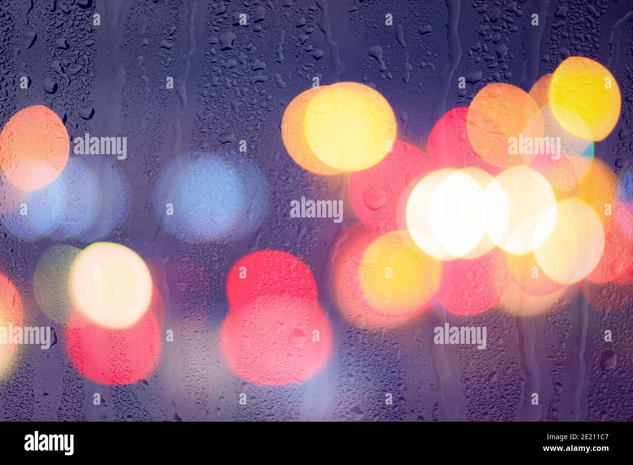 Night city lights and car headlights through rainy glass. Rain and bad