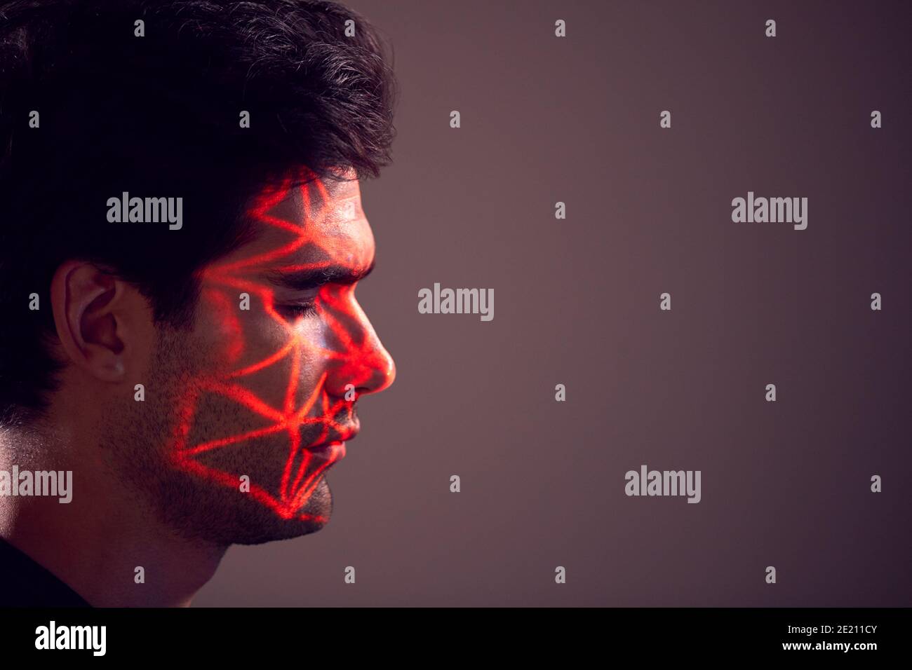 Facial Recognition Technology Concept As Man Has Red Grid Projected Onto Face In Studio Stock Photo