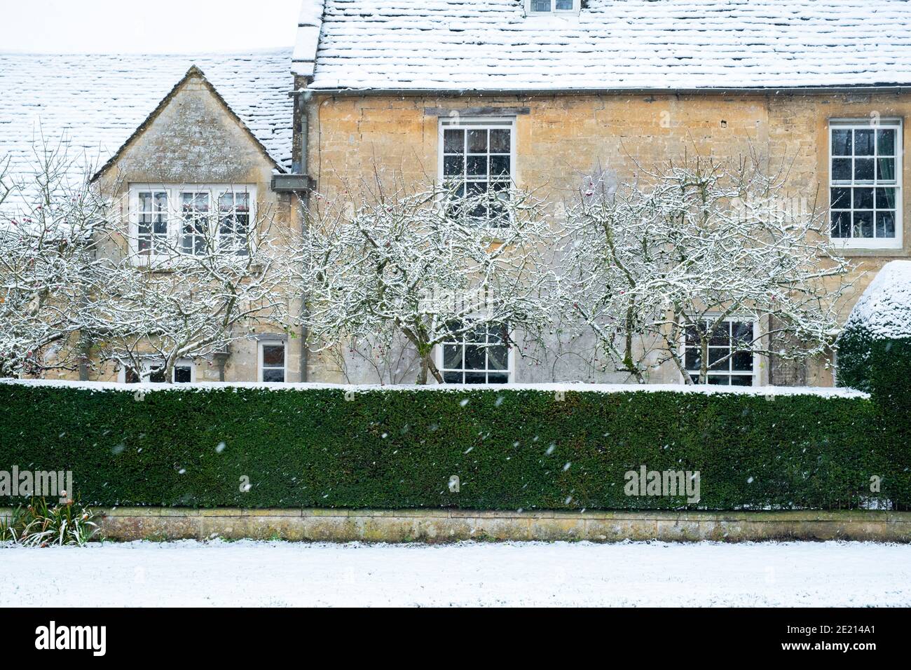 Grand cotswold stone house in the snow at Christmas. Taynton, Cotswolds, Oxfordshire, England Stock Photo