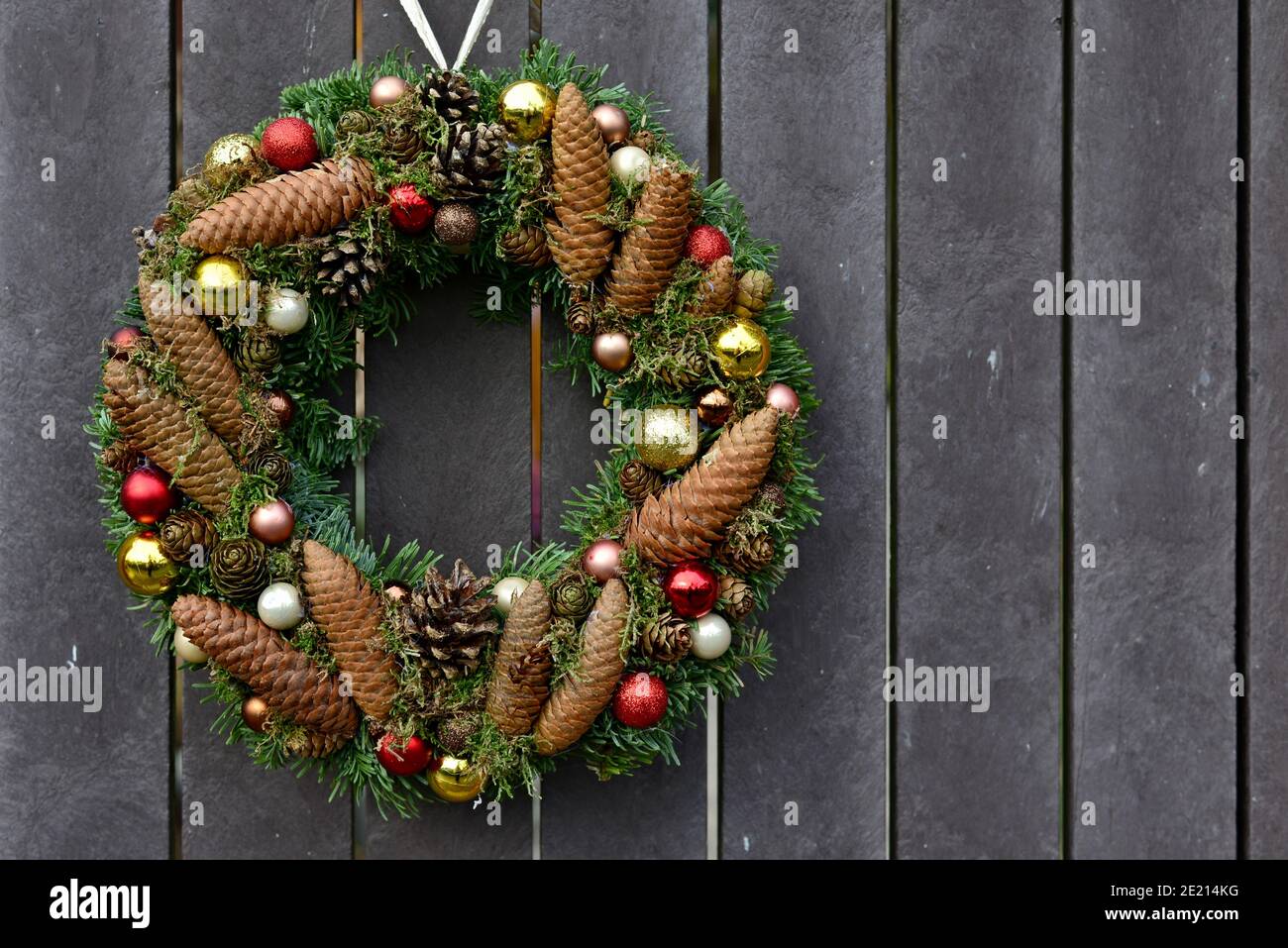 Christmas wreath with gold and silver ornaments and cones of coniferous trees. Circle of needles and cones decorated with Christmas decorations. Decor Stock Photo