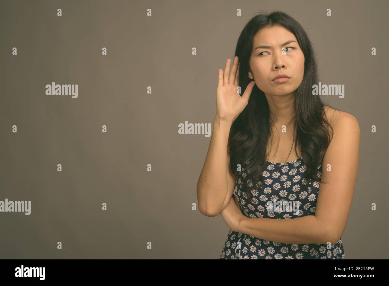 Asian woman wearing blue dress against gray background Stock Photo