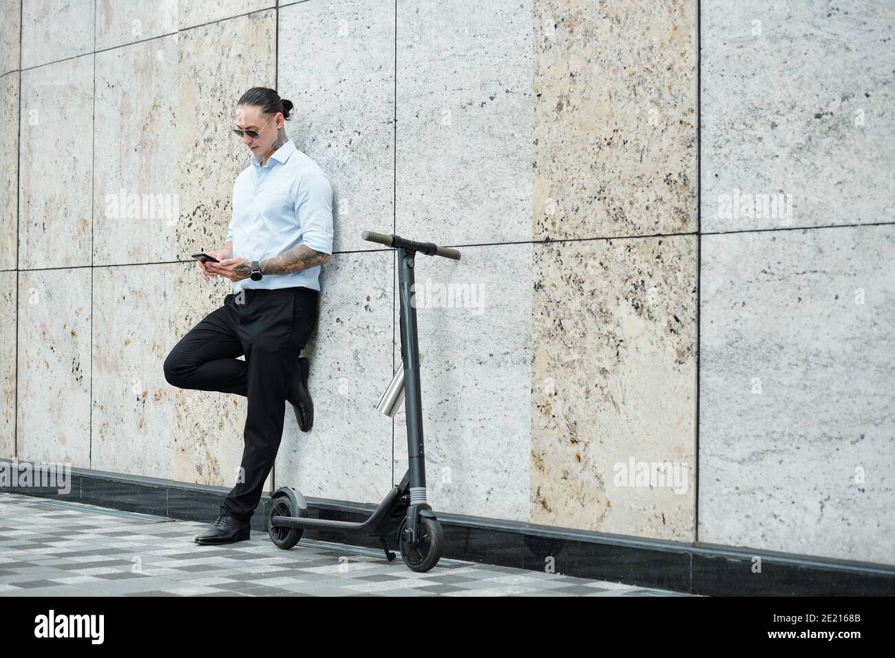 Stylish businessman texting colleagues Stock Photo