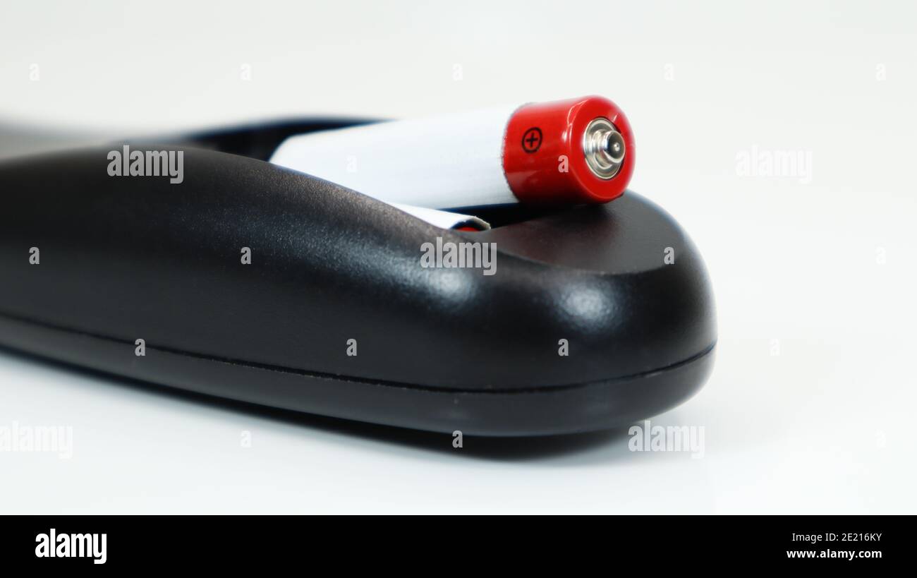 Black TV remote control with AAA alkaline batteries on a white