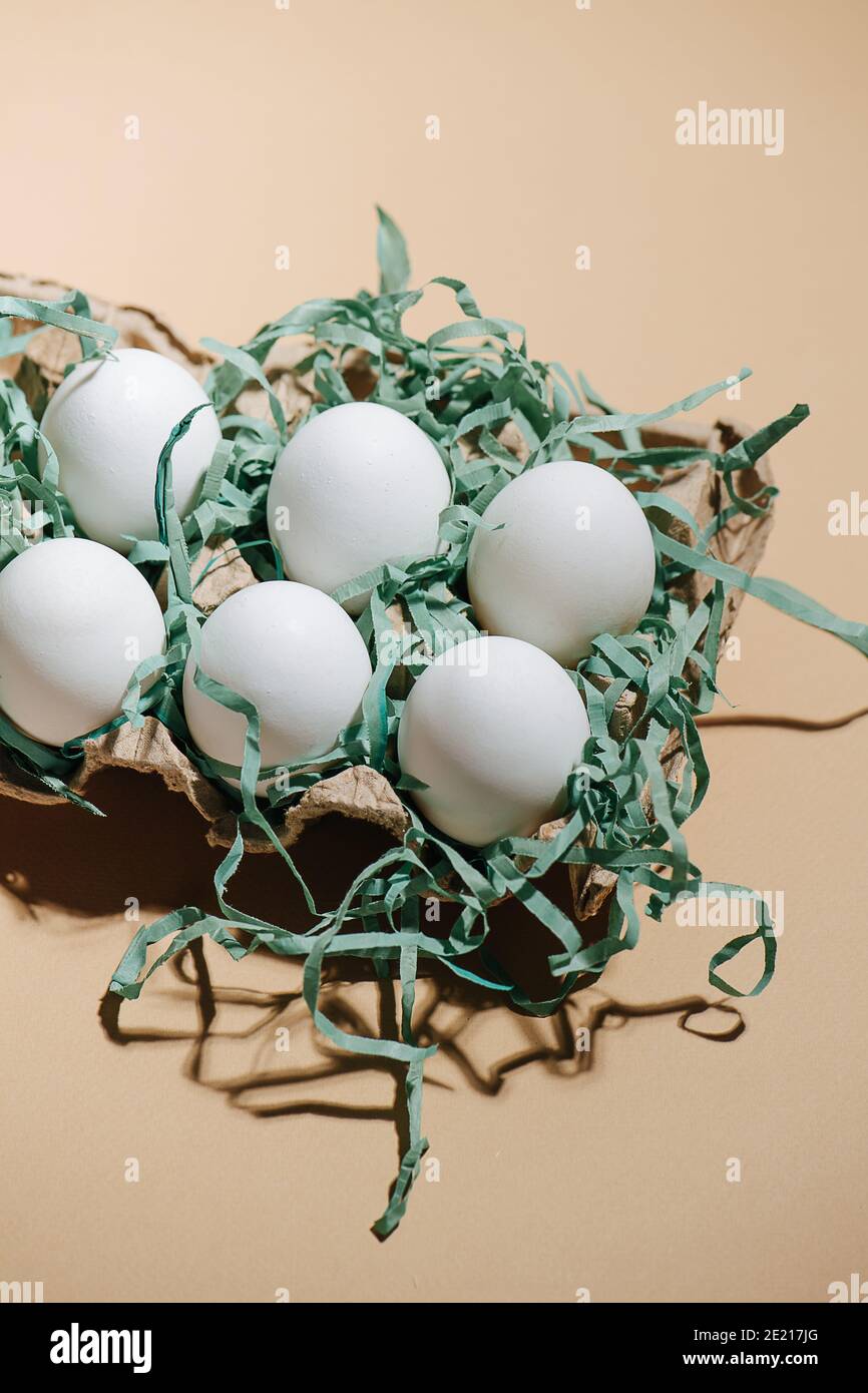 Six eggs in the package on a beige background Stock Photo