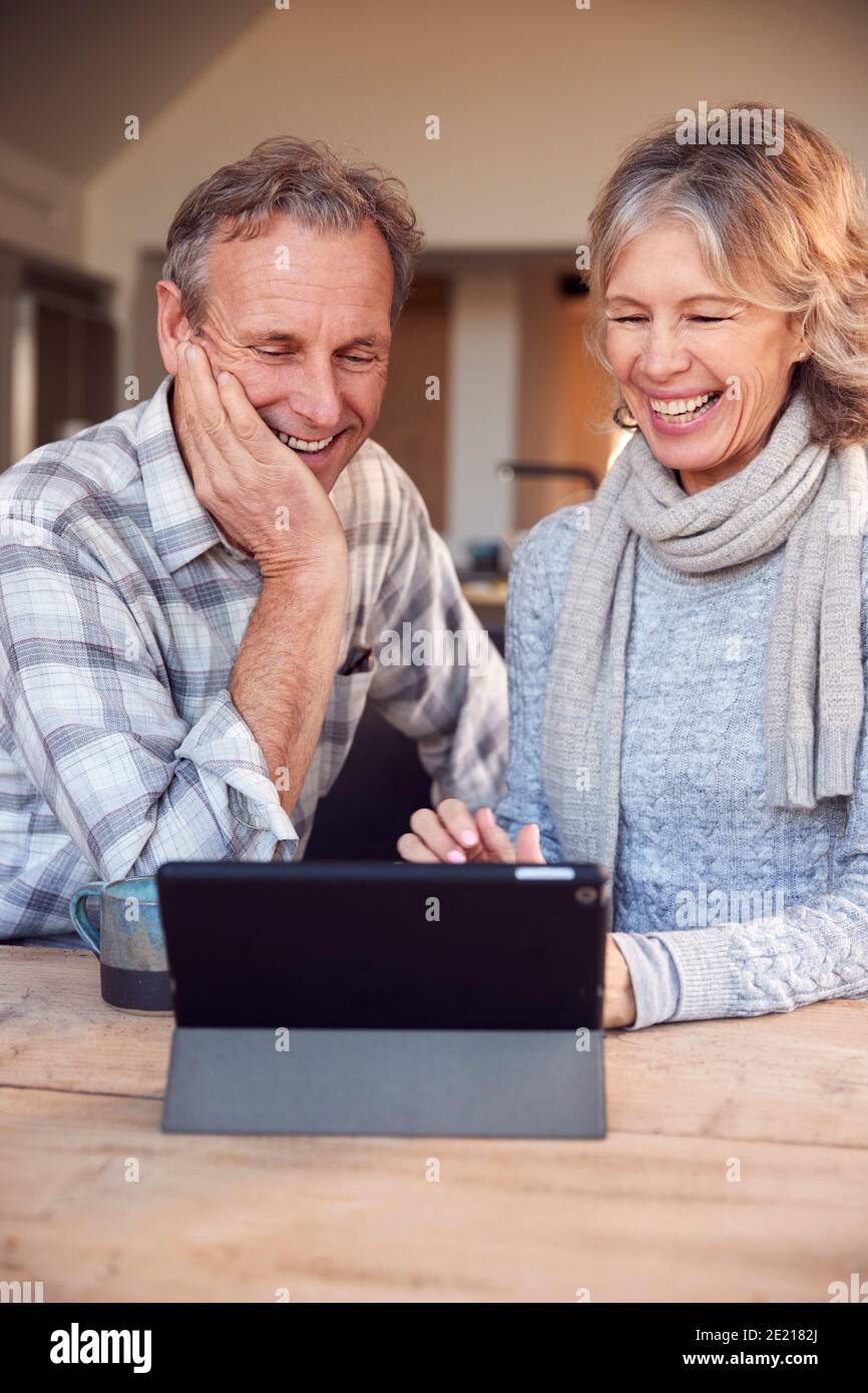 Retired Senior Couple At Home Buying Products Or Services Online Using Digital Tablet Stock Photo