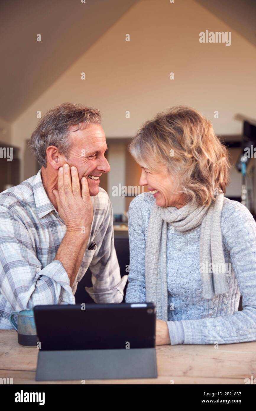 Retired Senior Couple At Home Buying Products Or Services Online Using Digital Tablet Stock Photo