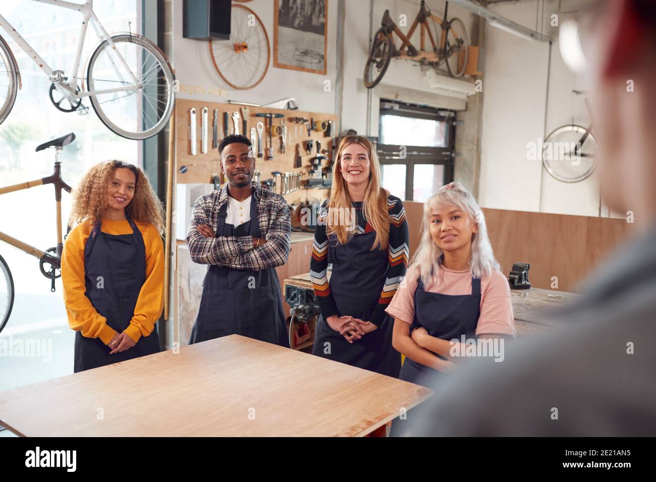 Multi-Cultural Team In Workshop Assembling Hand Built Sustainable Bamboo Bicycle Frame Stock Photo