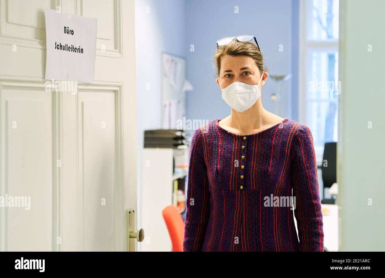 Berlin, Germany. 11th Jan, 2021. Antoneta Berisha, acting principal of John Lennon High School in Prenzlauer Berg, walks out of her office room wearing mouth-to-nose protection. As of today (11.1.2021), a tightened Corona Pandemic lockdown is in effect. There will be no mandatory face-to-face classes. Credit: Annette Riedl/dpa/Alamy Live News Stock Photo