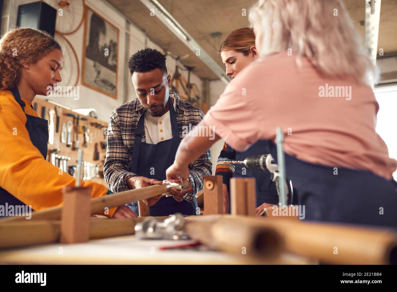 Multi-Cultural Team In Workshop Assembling Hand Built Sustainable Bamboo Bicycle Frame Stock Photo