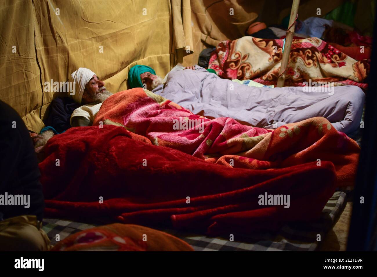 Delhi, India. 10th Jan, 2020. Protesters use blankets to keep themselves warm at night during the ongoing farmers' protest against the new farm laws, at Tikri Border.Indian farmers are protesting against the three farm acts passed by Parliament in September 2020. Local farmer unions, and political opponents say the law will put farmers at the 'mercy of corporates'. Credit: SOPA Images Limited/Alamy Live News Stock Photo