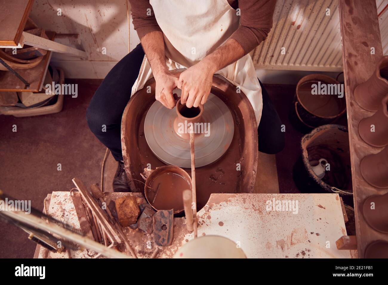 Close Up Of Male Potter Shaping Clay For Pot On Pottery Wheel In Ceramics Studio Stock Photo