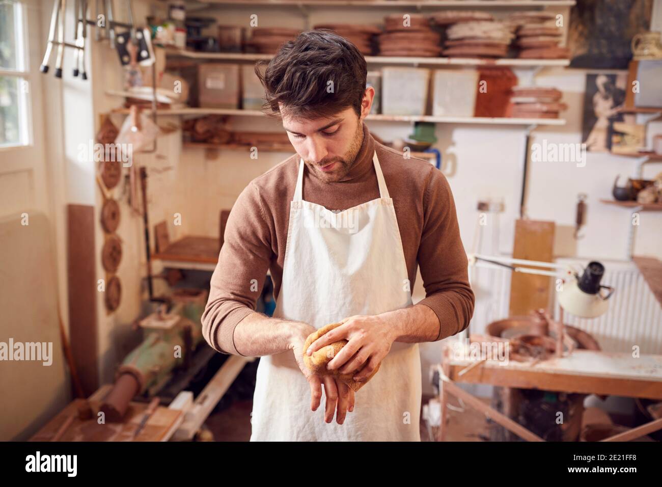 Male Potter Cleaning Hands With Sponge In Ceramics Studio Stock Photo